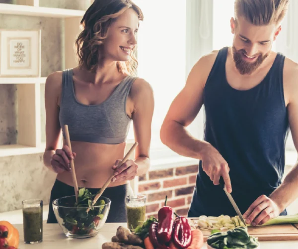 Pareja joven preparando una ensalada | Alimentación saludable clave para un bienestar sostenible | Alimentos Sostenibles