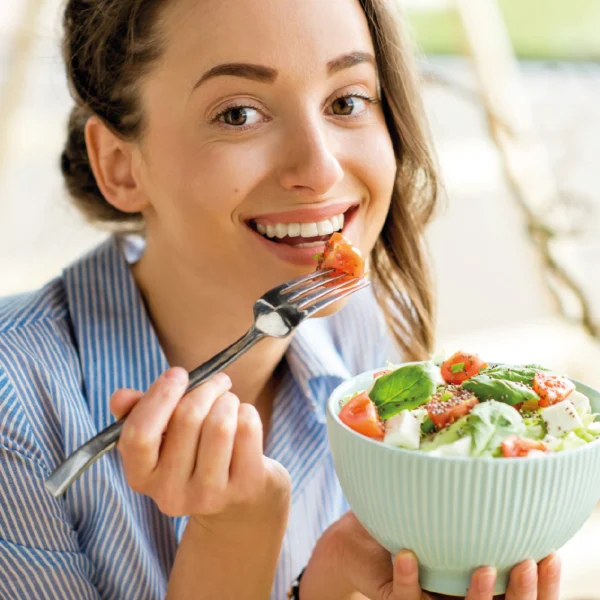 Mujer joven comiendo ensalada | Alimentación saludable clave para un bienestar sostenible | Alimentos Sostenibles